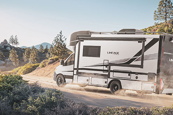 2025 Grand Design Lineage Series M Class C Motorhome Driving on a dirt road